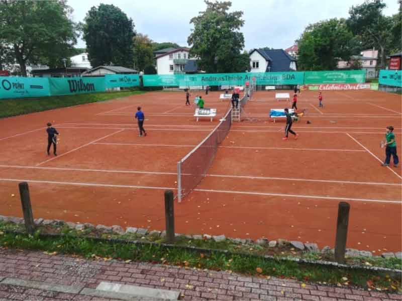 Kinder spiele Tennis auf einem Tennisplatz im Freien