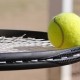 Tennisschläger balanciert Tennisball
